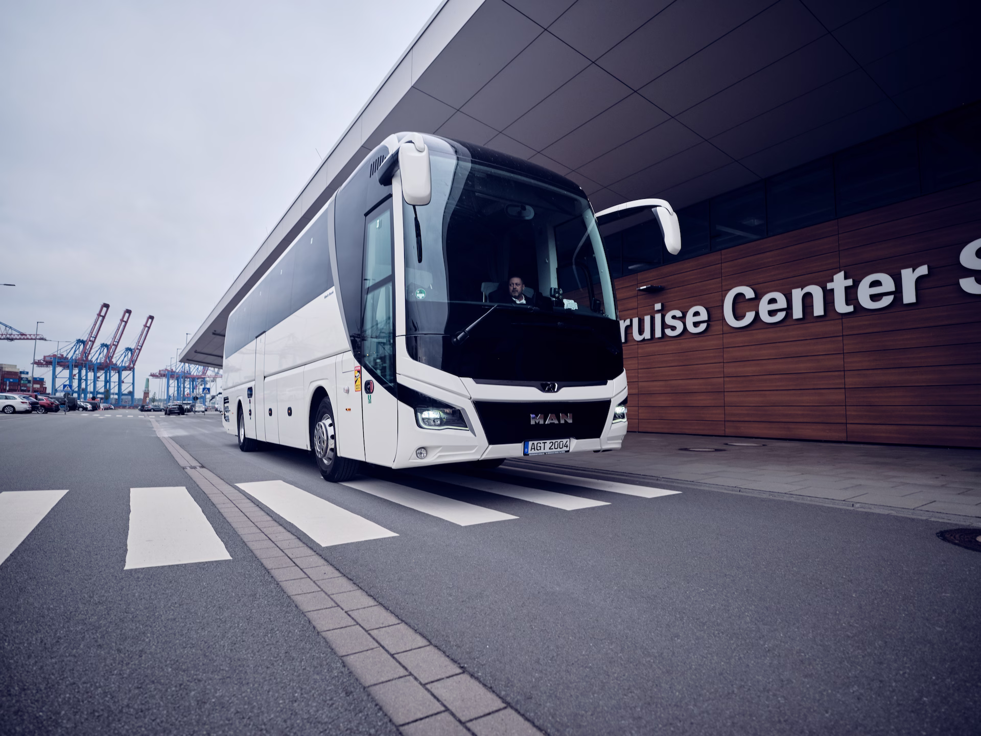 Reisebus der agt fährt an einem Terminalgebäude vorbei