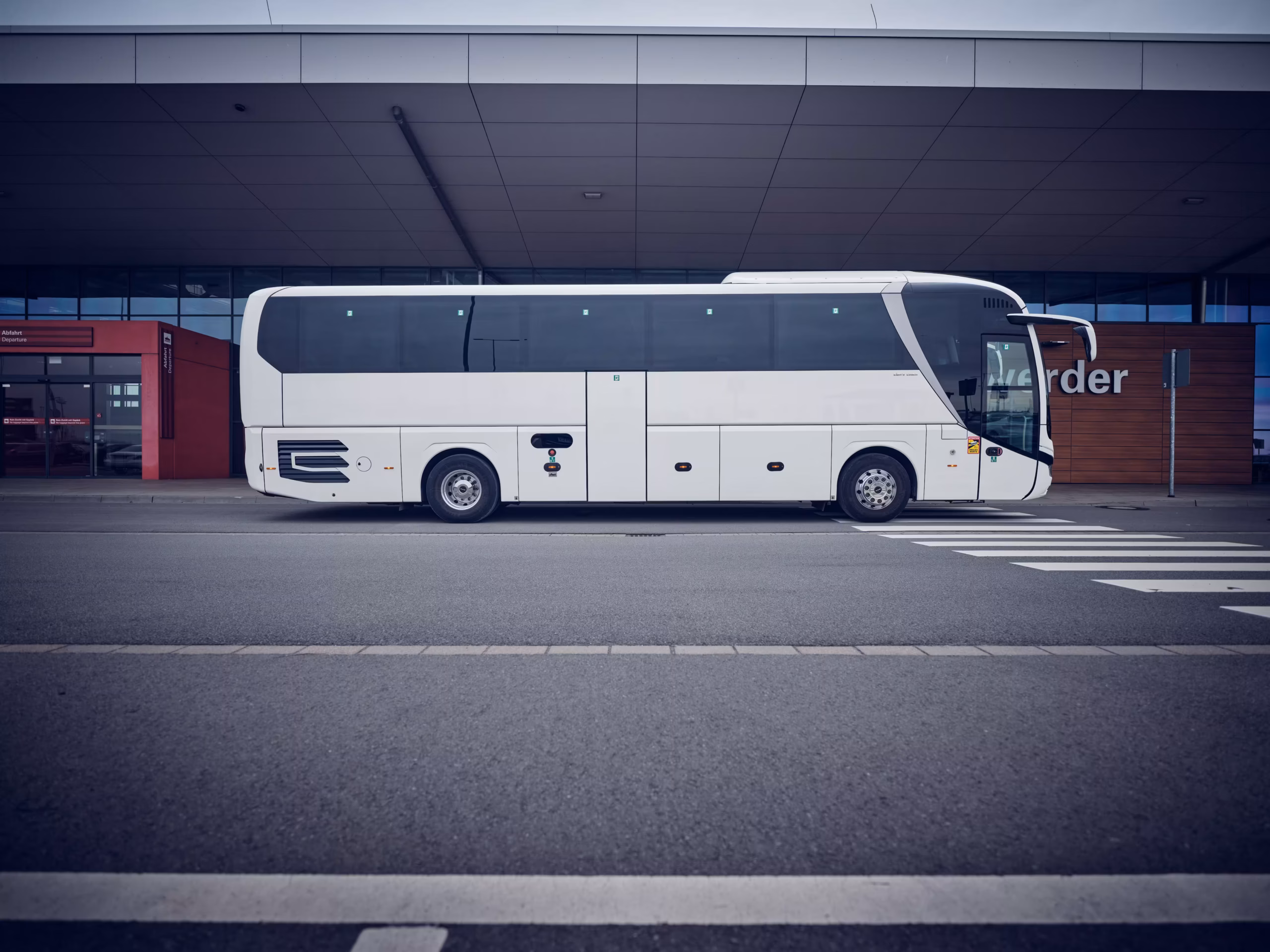 Weißer Reisebus in Seitenansicht vor dem Cruise Center Steinwerder in Hamburg.
