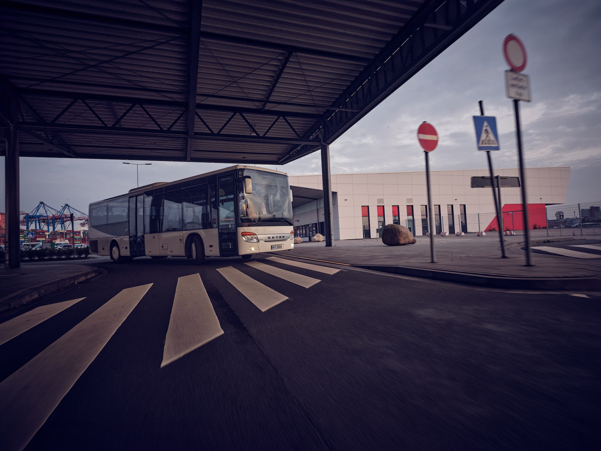 Linienbus fährt unter einer überdachten Zufahrt